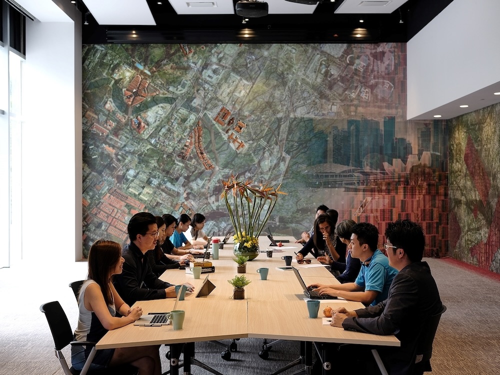 Staff having a discussion in a long meeting room. 