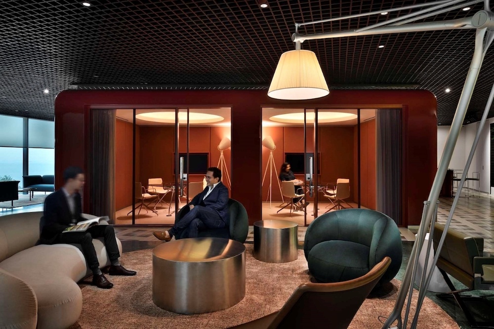 Two businessmen have a discussion in a meeting lounge. 